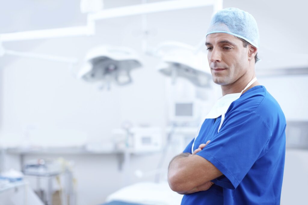 Lone surgeon with arms crossed, pensive