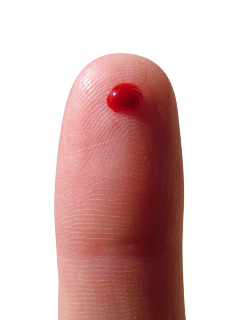 a pricked finger with a drop of blood