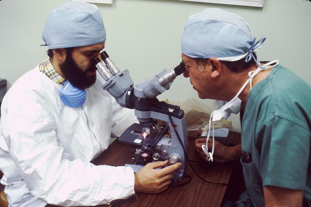 two doctors looking through a microscope