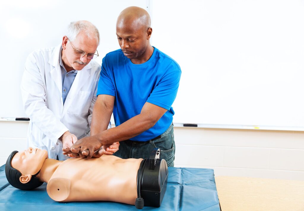 20535532 - doctor teaching first aid cpr techniques to an adult, african-american student. room for text.