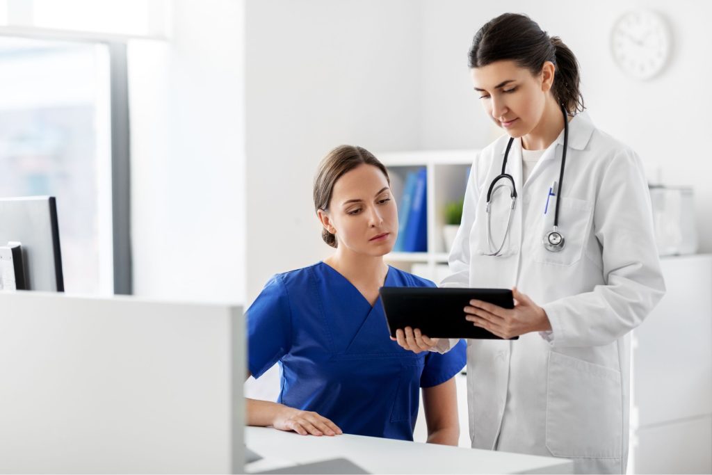 A female nurse and female doctor looking at a tablet together